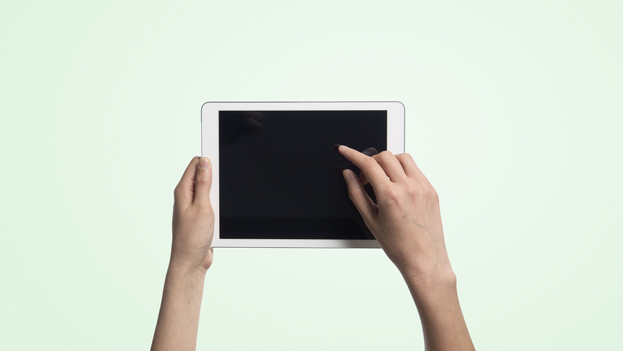 hand håller i läsplatta på grön bakgrund