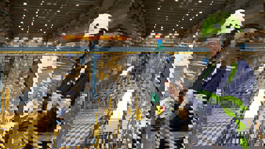 industriarbetare står vid datorskärm